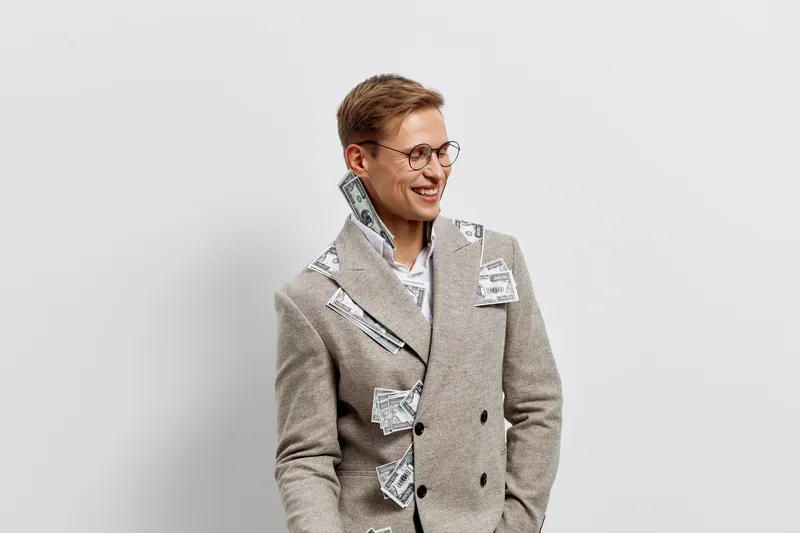 Smiling woman with short brown hair and glasses wearing a stylish plaid coat standing against a plain light gray background. Casual fashion and joyful expression. Concept: positive mood and modern sty