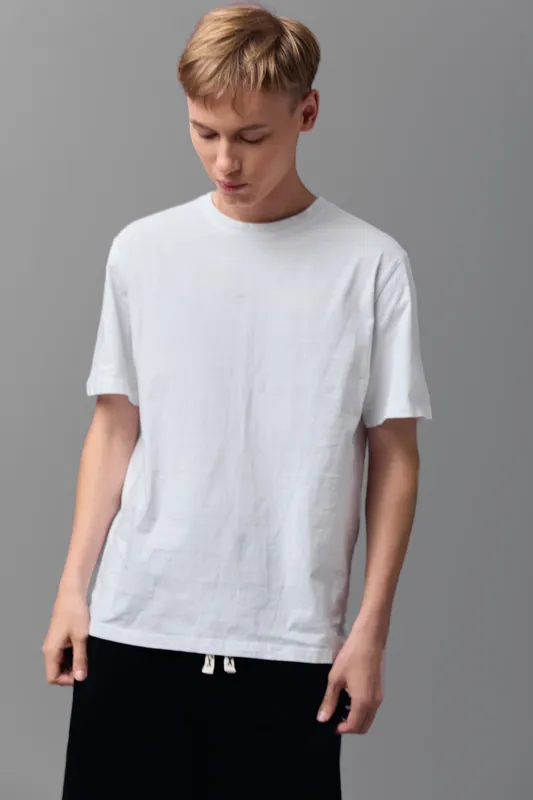 T shirt wearing boy standing in a studio with gray backdrop, casual wardrobe and relaxed posture, minimalist fashion for everyday wear and lifestyle photography