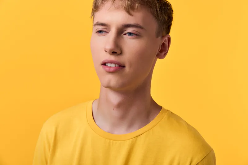 Young man, yellow shirt, yellow background, casual pose, studio shot, confident expression, fashion, male model, friendly mood, clean background for bright stock imagery suitable for lifestyle and