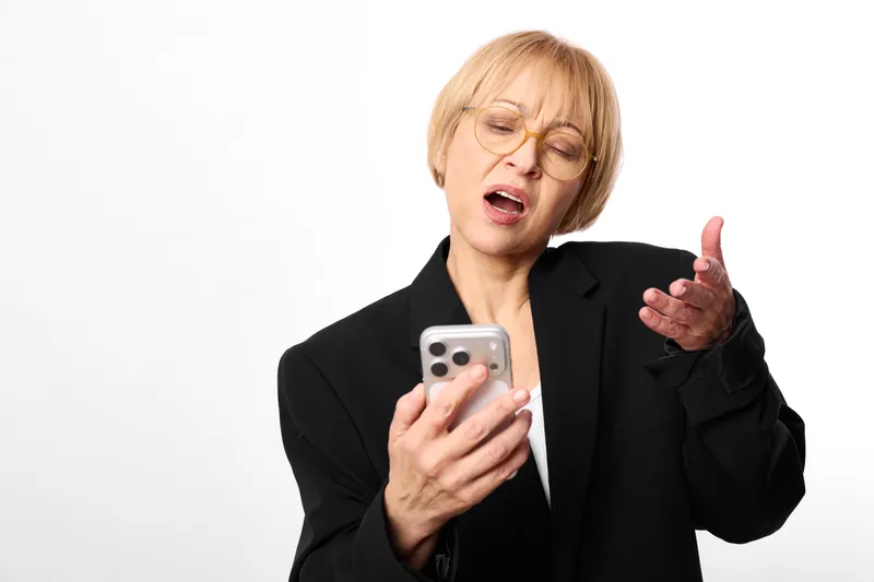 Woman smartphone office business stress communication annoyed gesture portrait, speaking with raised hand, holding mobile on white background, office frustration concept