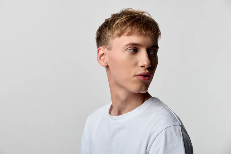 Young male, white t shirt, side profile, studio lighting, neutral background, fashion photography, clean look, minimalism, cropped shoulder, lifestyle, advertising, branding, editorial, classic,