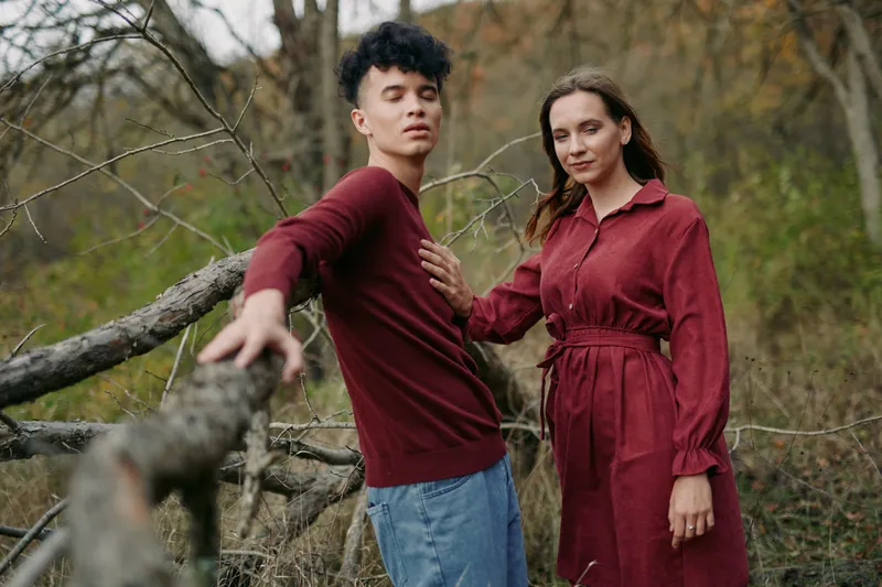 A candid portrait of two people in an autumn field, showing genuine connection and relaxed posture, with natural light and subtle emotion conveying authenticity and trustworthiness.