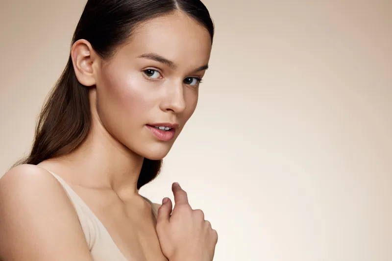 Elegant young woman with a natural look showcasing healthy skin and subtle beauty, perfect for fashion and skincare concepts