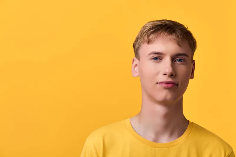 Male model against a bold yellow background wearing a matching yellow tee, clean modern style with soft studio lighting, calm and confident expression, ideal for fashion, lifestyle, or branding