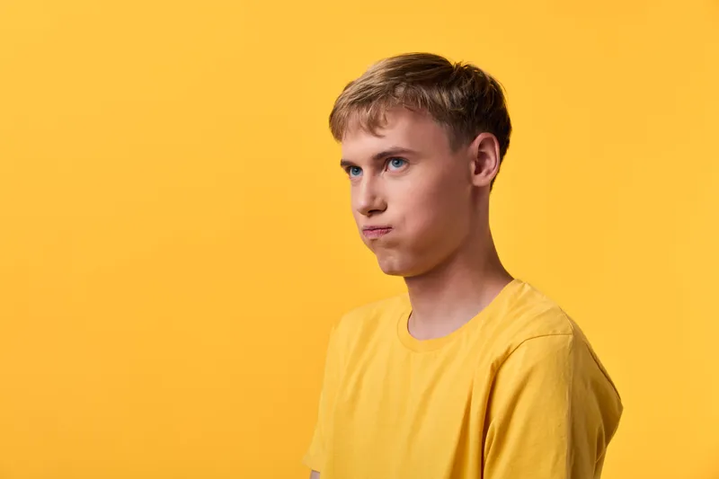 Yellow themed image featuring a man wearing a yellow shirt with a neutral expression in a studio setting, bright background, suitable for fashion, lifestyle and branding projects