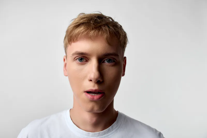 Close up of a man with a surprised face, wearing a shirt under studio lighting, capturing a crisp, natural mood for stock imagery and versatile commercial use