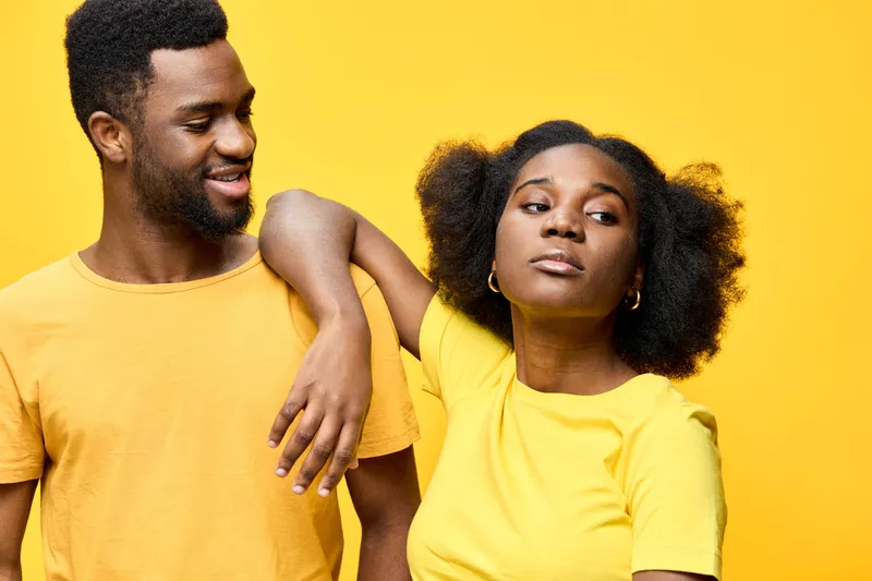 Happy young couple in yellow outfits against a vibrant yellow background, showcasing love, connection, and joy in a bright and cheerful atmosphere