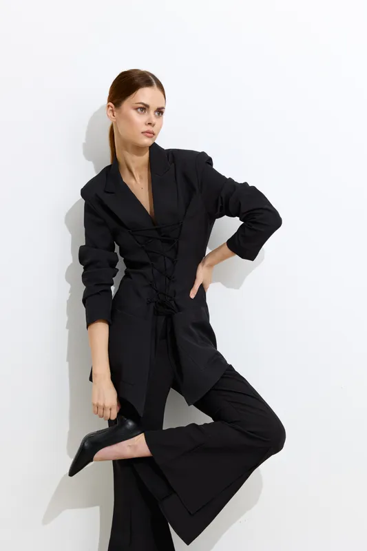 fashion woman in stylish black blazer and pants posing confidently against white background, modern look, trendy outfit, sleek hairstyle