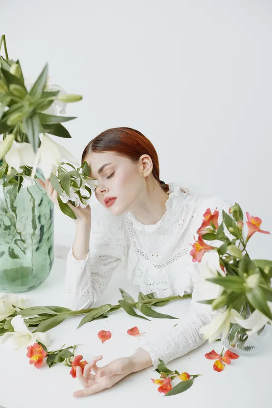 Elegant woman resting among fresh flowers, showcasing tranquility and beauty, perfect for spring themes and lifestyle concepts