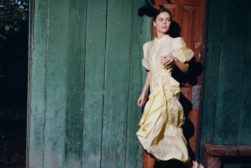 Woman in vintage yellow dress portrait authenticity inclusivity wooden backdrop