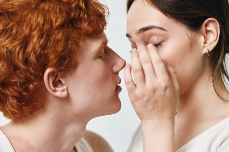 Couple, communication and emotion with young man whispering to woman, intimacy and quiet moment in indoor bright setting, closeup and bonding between two people.