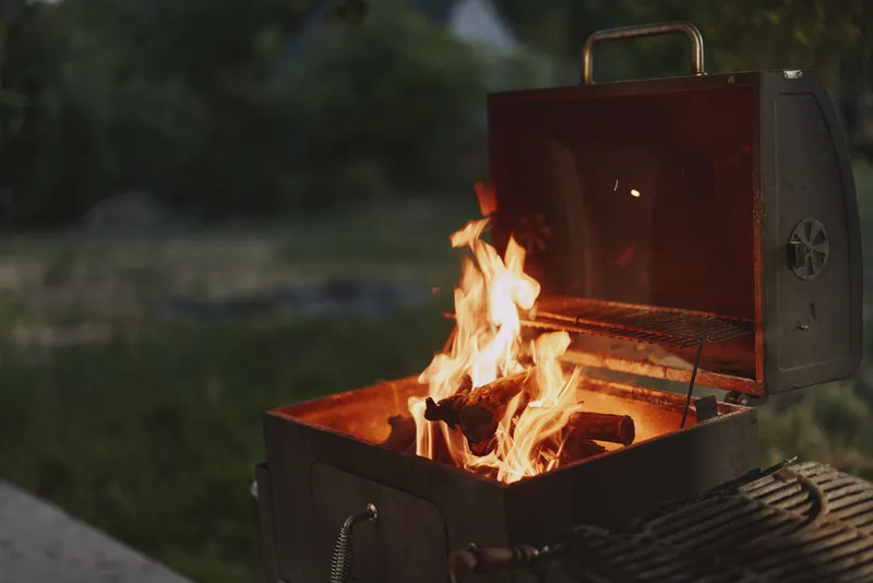Cozy summer barbecue with a glowing grill, vibrant flames, and outdoor ambiance for gatherings and celebrations