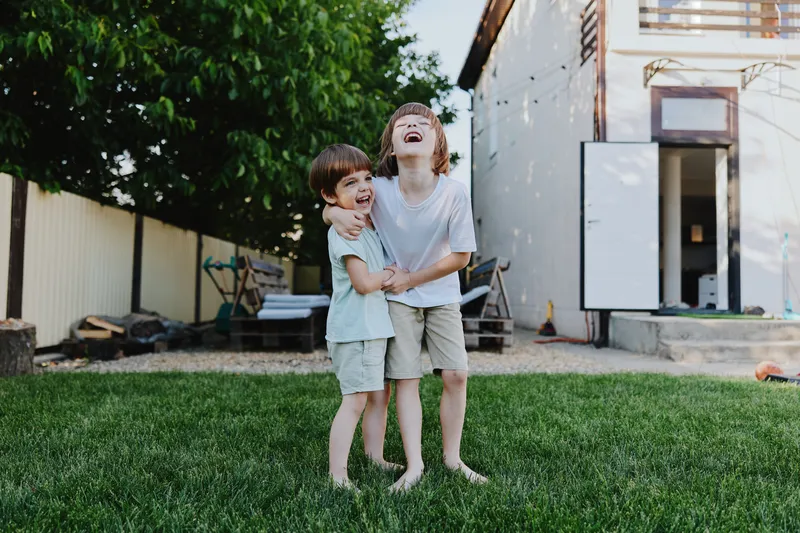 Joyful kids playing together in a sunny backyard, showcasing happiness, laughter, and friendship in a vibrant outdoor setting.