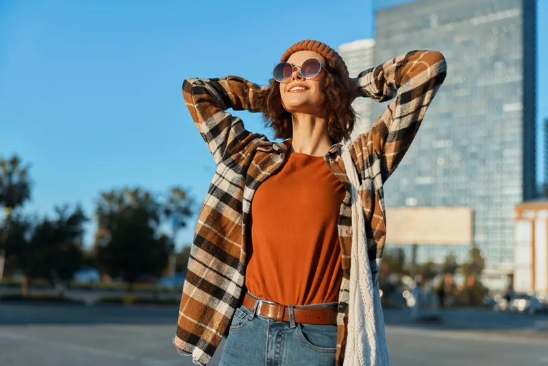 woman portrait in city at golden hour, candid lifestyle capture of a smiling model in casual fashion. Authenticity, mindful living and emotional storytelling shape an urban golden hour glow and