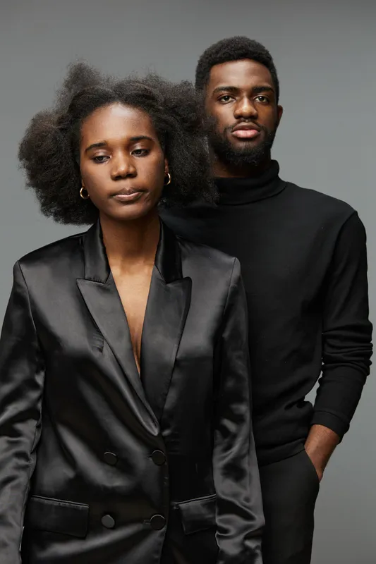 Elegant Black Models in Modern Fashion Attire Conveying Subtle Emotions Against a Neutral Background