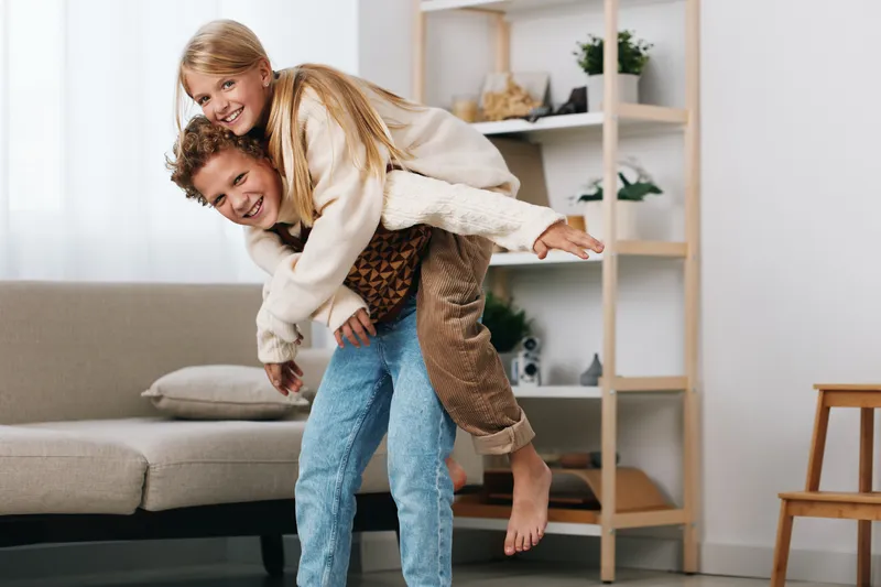 Authentic moment showcasing a playful game as a couple share a joyful piggyback on a cozy living room day, blending lifestyle warmth with candid emotion.