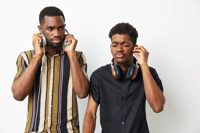 Stylish black men listening to music with headphones, showcasing emotions of concentration and enjoyment. Perfect for music-related themes and lifestyle concepts.