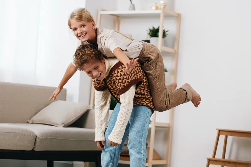 Authenticity and playful joy in a school inspired lifestyle moment, kids at home enjoying lighthearted mischief and shared laughter during a candid game.