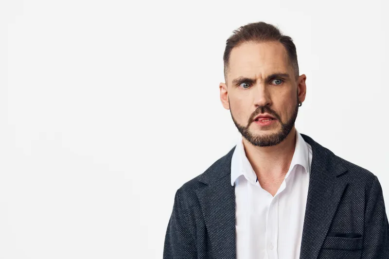 Portrait of a business professional man with a serious emotion, isolated colored background, conveying focus and confidence in a corporate setting, with clean lighting and strong posture.