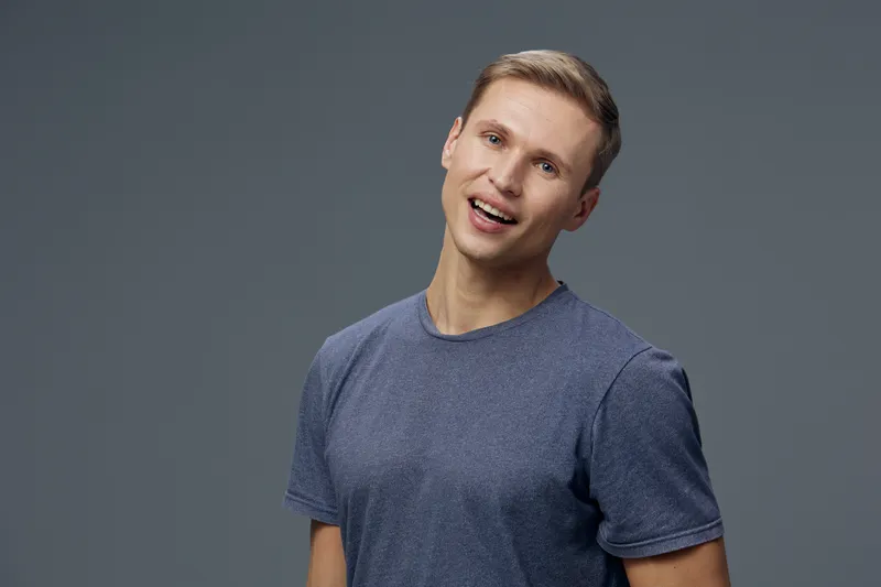 young smiling caucasian man in blue t-shirt look camera isolated on grey background digital detox mental health concept