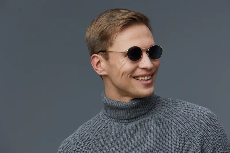 smiling caucasian man wear gray turtleneck sweater sunglasses look side isolated on plain background mental health gadgets concept