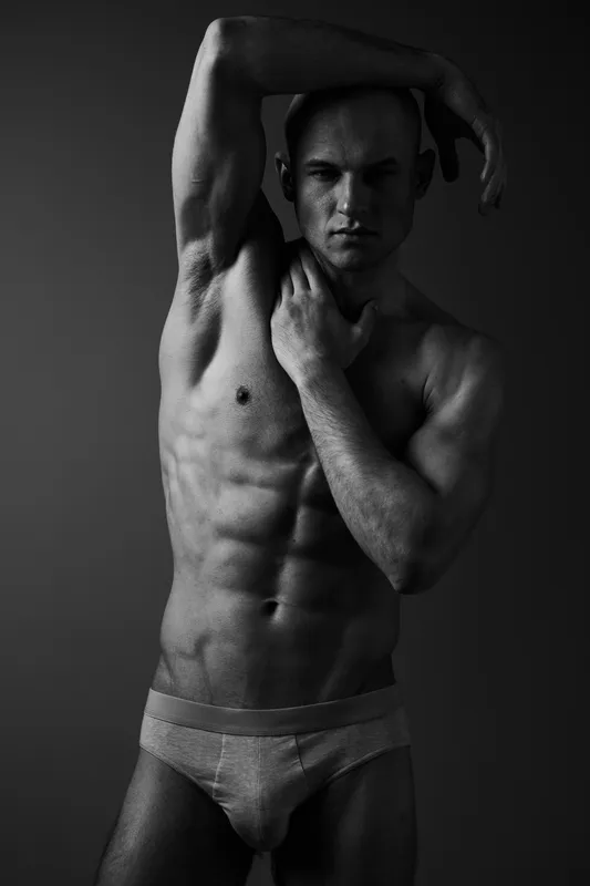 Striking black and white portrait of a muscular man showcasing strength and confidence, perfect for fitness and wellness themes, capturing intense emotion effectively.