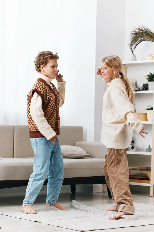Authenticity plays a central role in this scene, showing children at home wearing playful teacher and student outfits, exploring school life with genuine curiosity and a relaxed lifestyle vibe.
