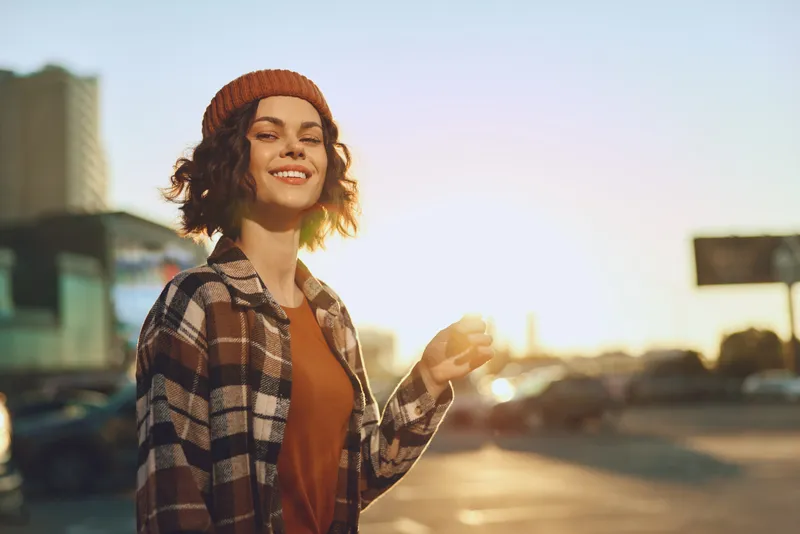 woman smile golden hour candid urban lifestyle authenticity beanie portrait sunset. Candid lifestyle scene with golden hour glow, mindful living mood and emotional storytelling in a modern city