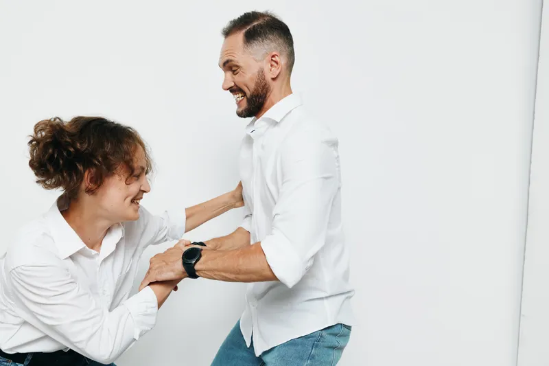 Businessman in a white shirt stands with a colleague against a pure white background, exuding confidence, focus, and positive energy in a professional setting.