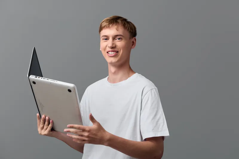 Man in a white t shirt holding a tablet, showcasing digital learning and modern technology in a casual studio setup, education theme, online study, approachable and confident communication