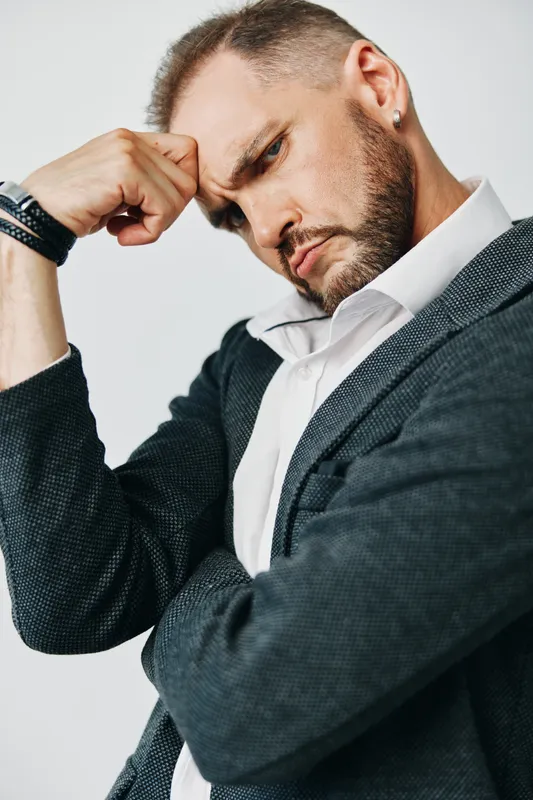 Thoughtful, professional man against an isolated colored background, exuding focus and calm. The image conveys a pensive mood and leadership vibe, ideal for corporate branding and executive profile