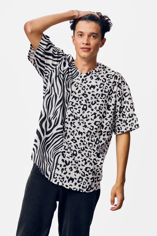 young man wearing a black and white animal print shirt, casual style, mixed patterns, standing pose, light background, relaxed expression