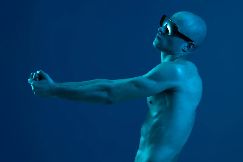 Artistic portrayal of a man in blue tones, showcasing emotion and movement. The image captures a unique essence, emphasizing the figure's pose and style.