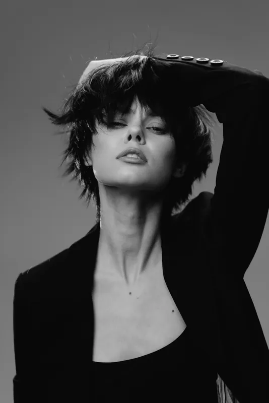 Monochrome portrait of a stylish woman with short hair in a black jacket expressing confidence and mystery.