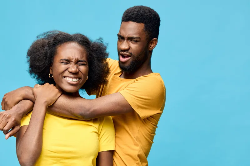 Happy couple in matching yellow shirts, showcasing joy and fun against a vibrant blue background, perfect for lifestyle and love themes
