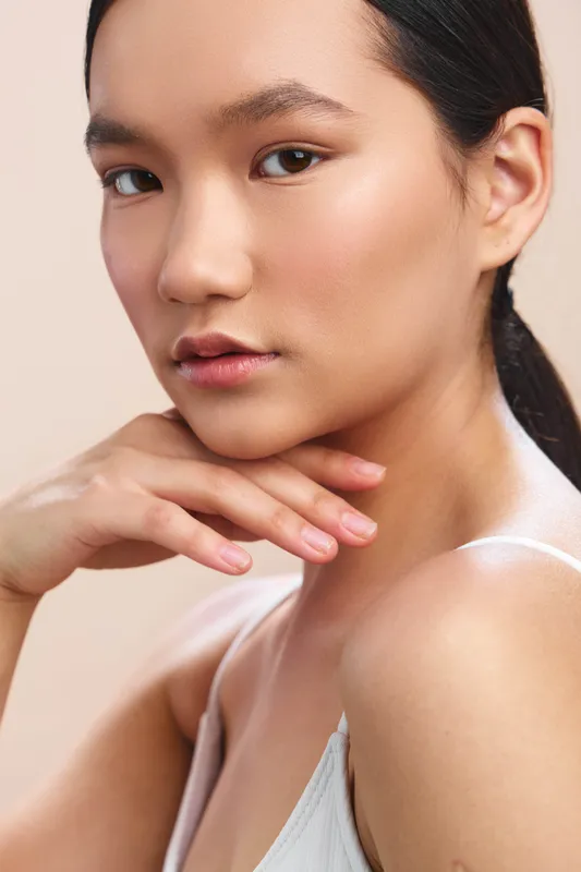 asian woman portrait closeup with soft studio lighting conveys calm confidence and natural beauty, a poised expression, smooth skin, and a gentle, elegant mood.