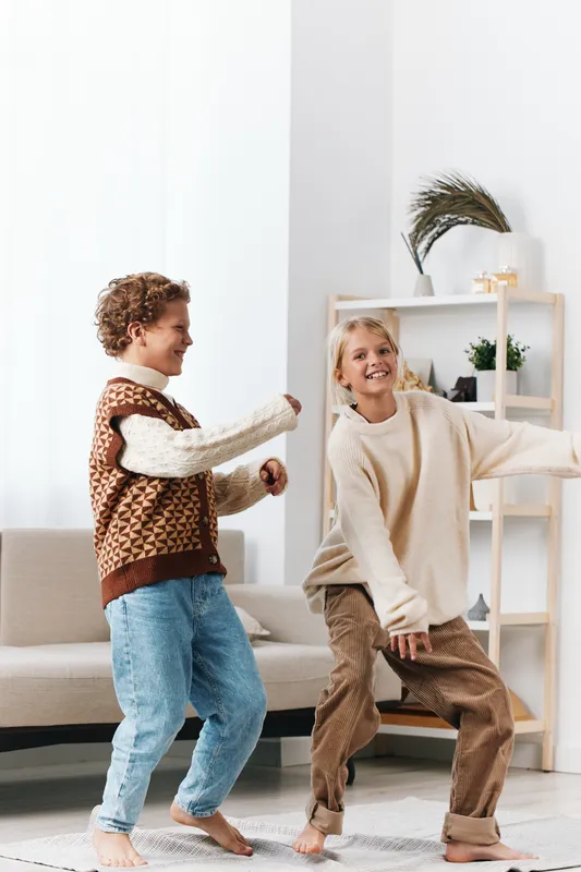 Authentic scene of children at play, capturing a school inspired lifestyle moment as youngsters dance and laugh in a cozy living room.