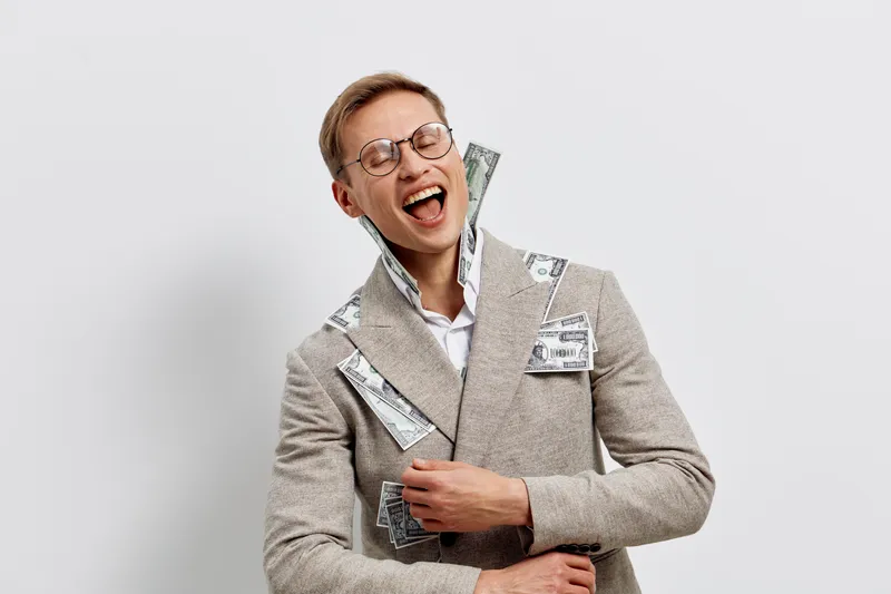 happy young caucasian man smiling with money cash in coat pocket laughing joyful isolated on white background digital nomad freelance concept