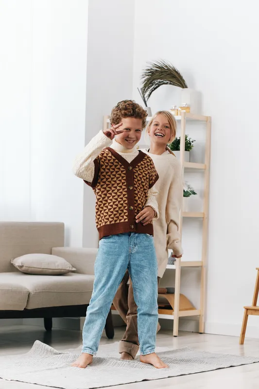 Authentic scene of children at play at home, capturing joyful mischief and friendship as they pretend to attend class in a cozy living room setting.