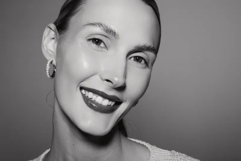 Closeup of a smiling white woman with light skin and dark hair in studio. Concept of happiness, beauty, and natural skin care.