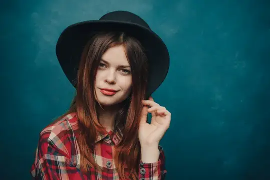 Женщина-модель в клетчатой рубашке на голубом фоне