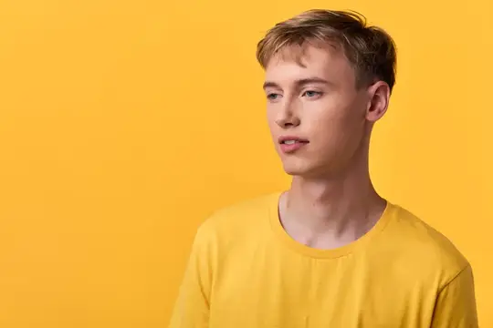 Светловолосый парень в жёлтой футболке на жёлтом фоне