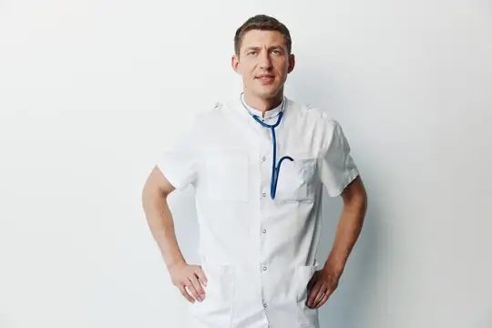 Молодой врач в белом халате со стетоскопом на шее