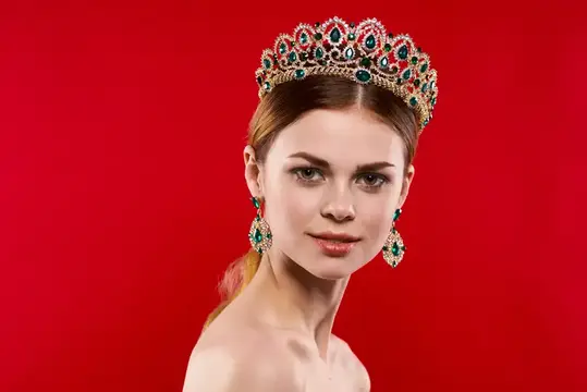 Привлекательная женщина с обнаженными плечами, украшения, косметика, позирует в студии
