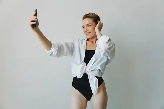 Девушка-подросток, блогер, фотографирует и снимает себя на видео на телефон для контента в социальных сетях