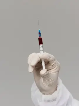 Рука в медицинской перчатке в лаборатории, вакцина, лечение