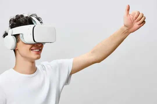 Улыбающийся парень в VR-очках поднимает большой палец вверх