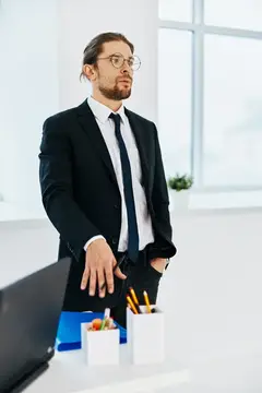 Мужчина в костюме в офисе с документами, руководитель