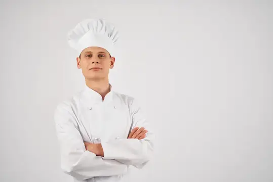 Шеф-повар мужского пола занимается приготовлением пищи, работая профессионально