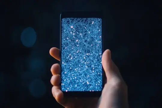 Крупный план руки, держащей смартфон с абстрактным синим сетевым узором на экране, символизирующий цифровую связь и современные технологии